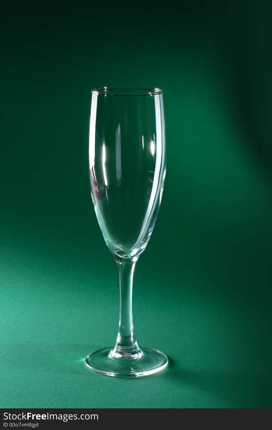 Single champagne glass on green background