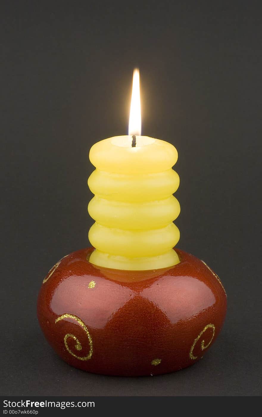 Yellow candle on black background