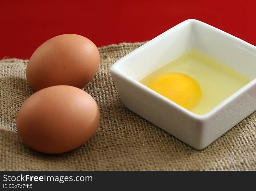 Healthy raw eggs on a red background