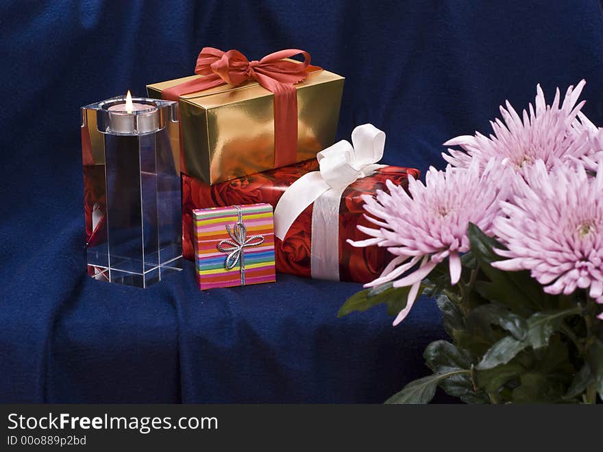 Gifts and candle behind flowers