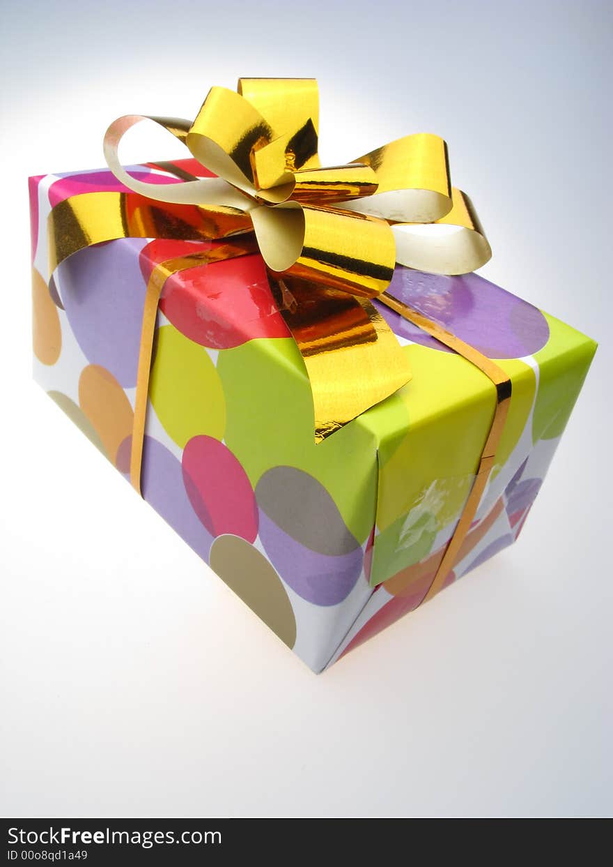 Gift in  box packed into  bright color paper  on white background