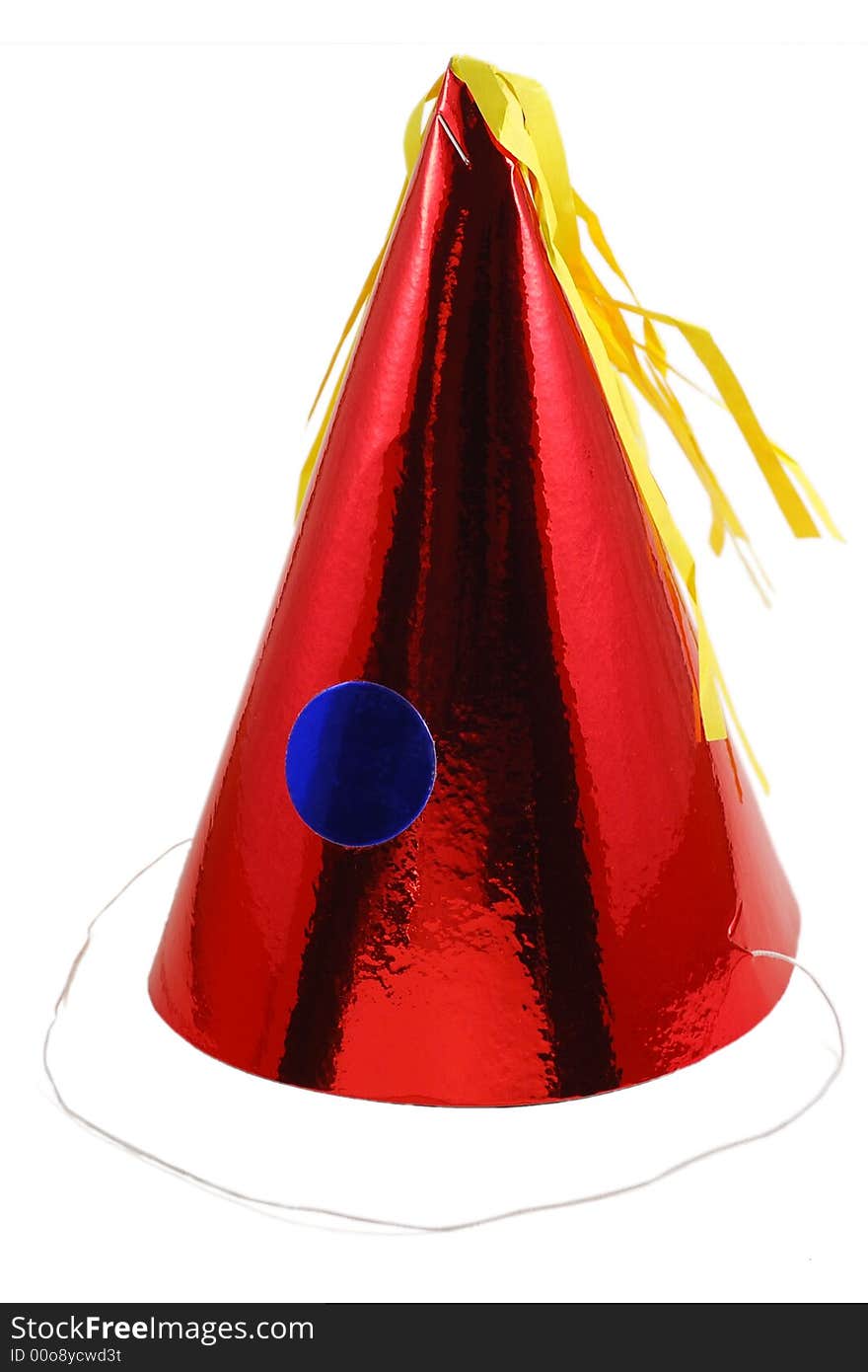 A shiny red party hat with blue circle and yellow tassle. A shiny red party hat with blue circle and yellow tassle