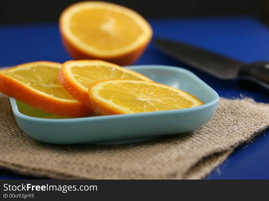 Orange slices on a plate on a blue table