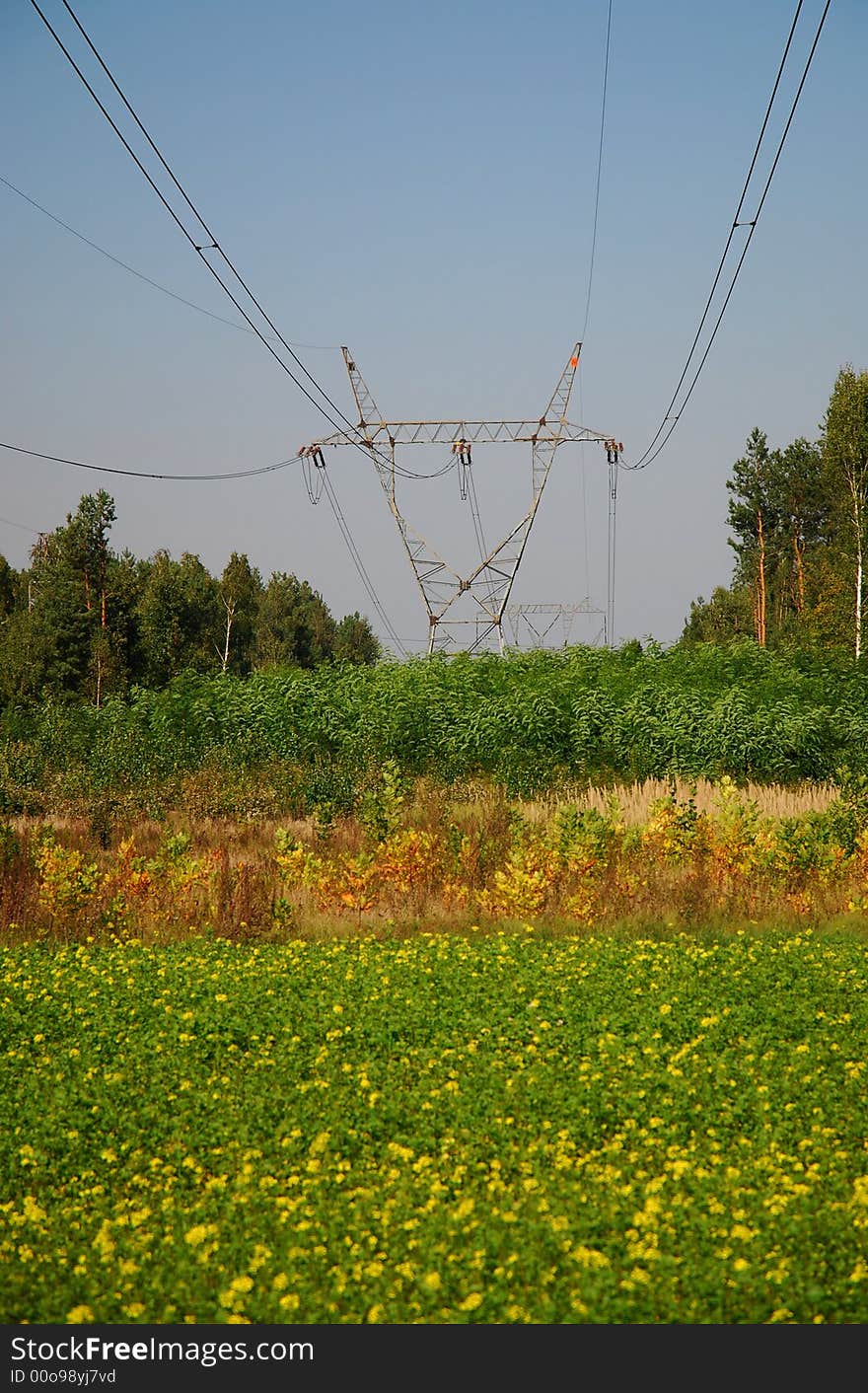 High voltage tower over cloudy blue sky