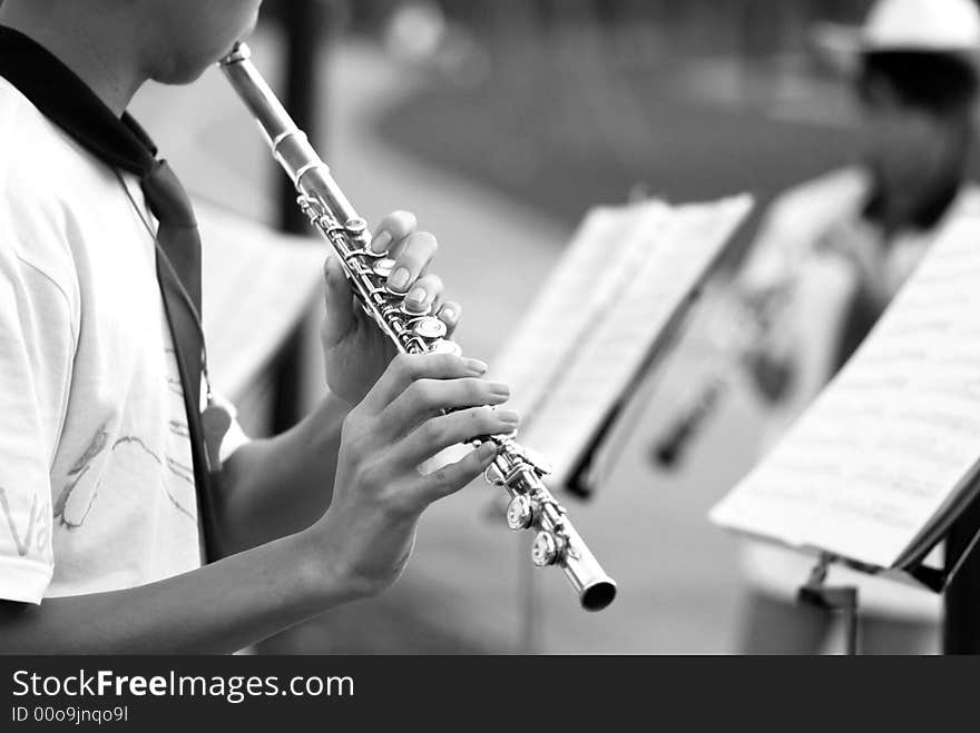 Young boy playing the flute at an outdoor public performance