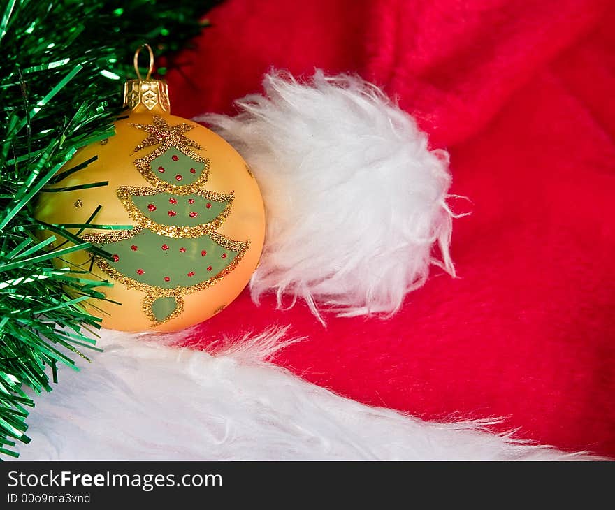 Christmas tree on a glass ball sitting on a santa hat with tinsel trimming