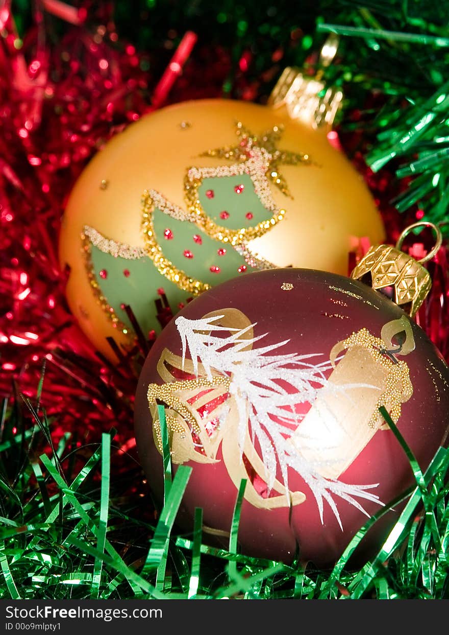 Red and gold Glass balls with candle and tree on red and green tinsel. Red and gold Glass balls with candle and tree on red and green tinsel