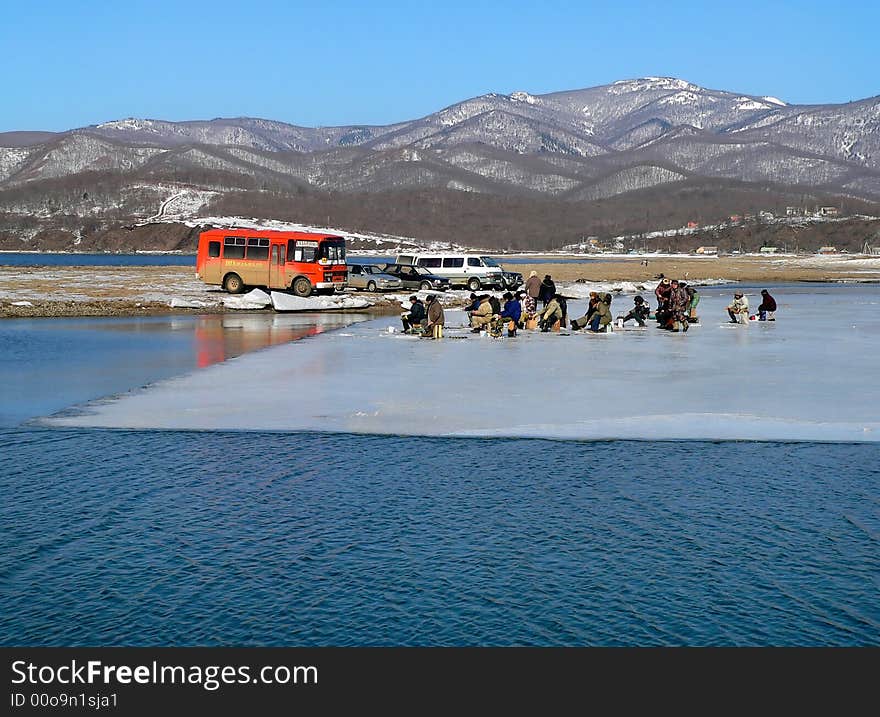 A group of the fishers is on ice cake. Early spring. Russian Far East, Primorsky Region, Japanese sea, Sokolovskaya bay. A group of the fishers is on ice cake. Early spring. Russian Far East, Primorsky Region, Japanese sea, Sokolovskaya bay.