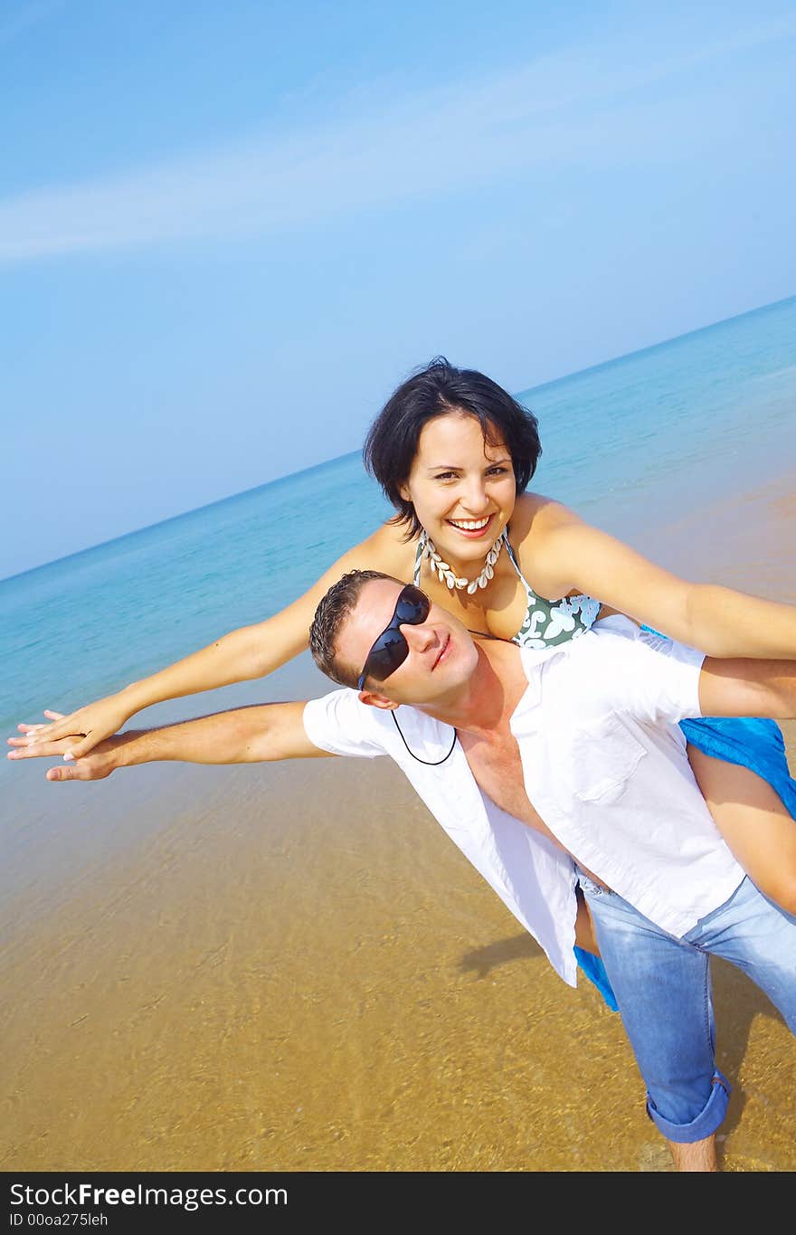 A portrait of attractive couple having fun on the beach. A portrait of attractive couple having fun on the beach