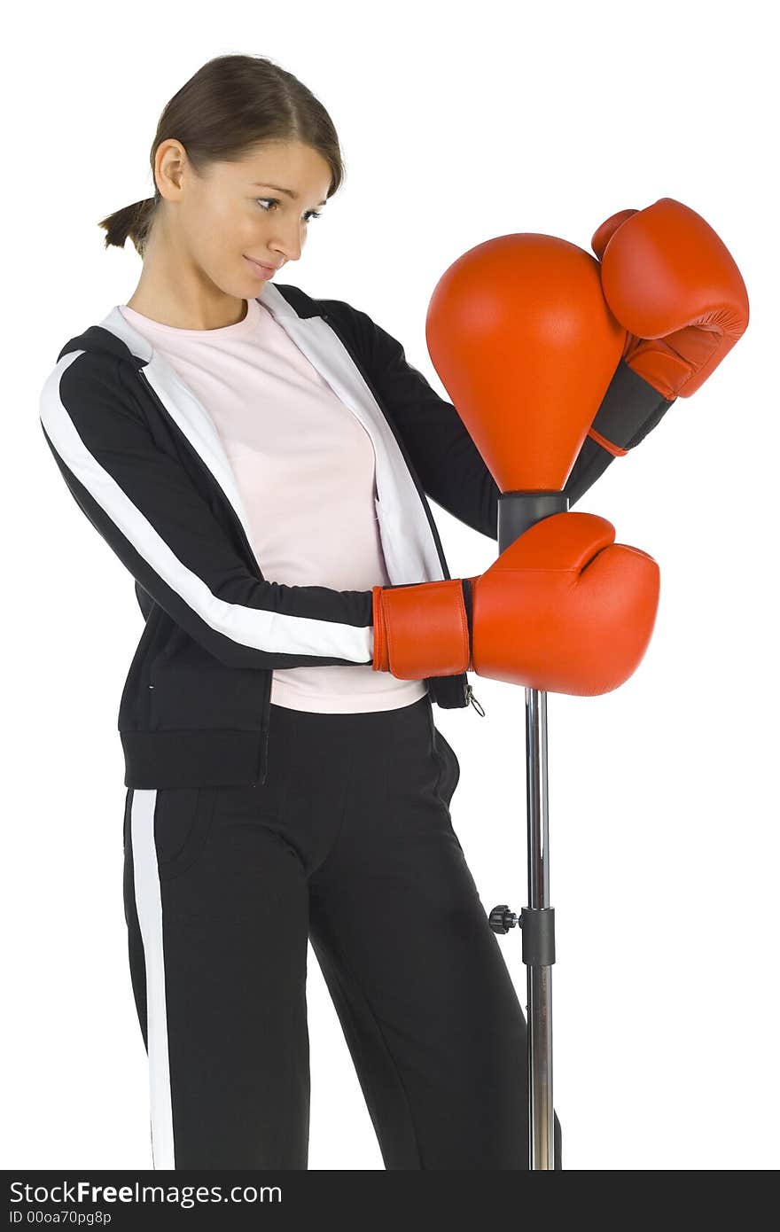 Young beauty with boxing gloves. Hugging punch bag. Smiling and looking at bag. White background, side view. Young beauty with boxing gloves. Hugging punch bag. Smiling and looking at bag. White background, side view