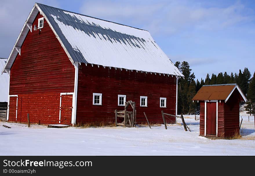 Red barn and matching outhouse in early winter in central Idaho. Red barn and matching outhouse in early winter in central Idaho