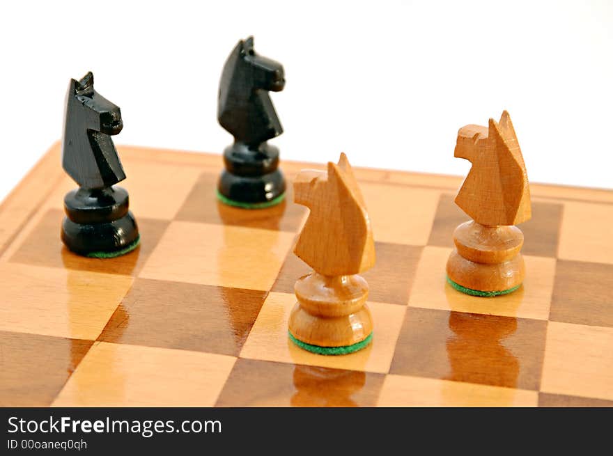 Two pairs of horses on chess board on white background isolated