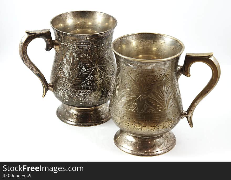 Two vintage silver beer tankards isolated over white background. Two vintage silver beer tankards isolated over white background