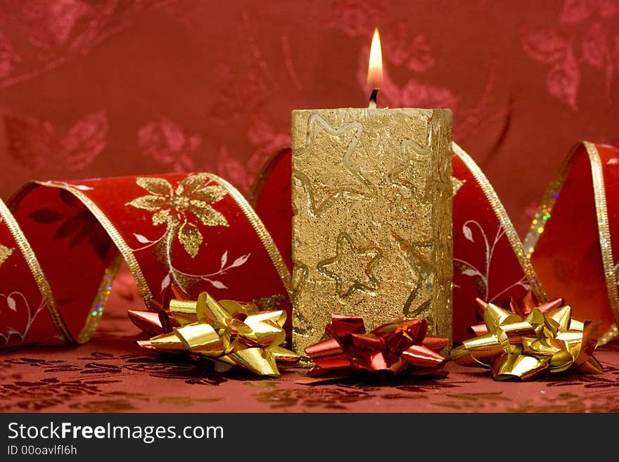 Golden candle on red background