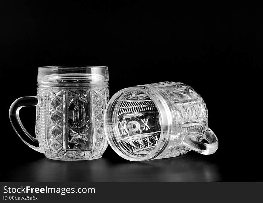 Two crystal glass with reflection isolated on a black background