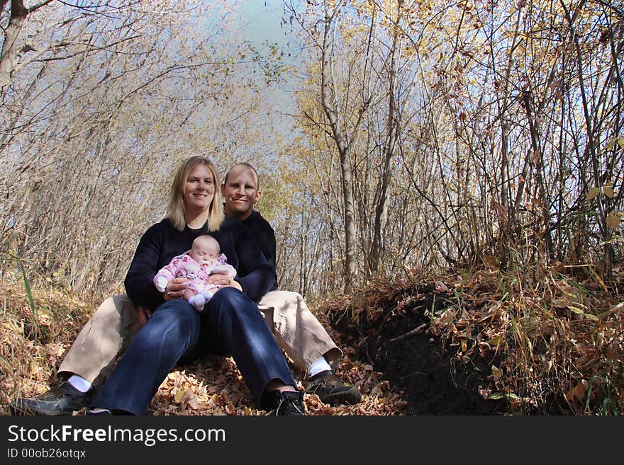 A happy young family enjoying a day in the Autumn woods. A happy young family enjoying a day in the Autumn woods.