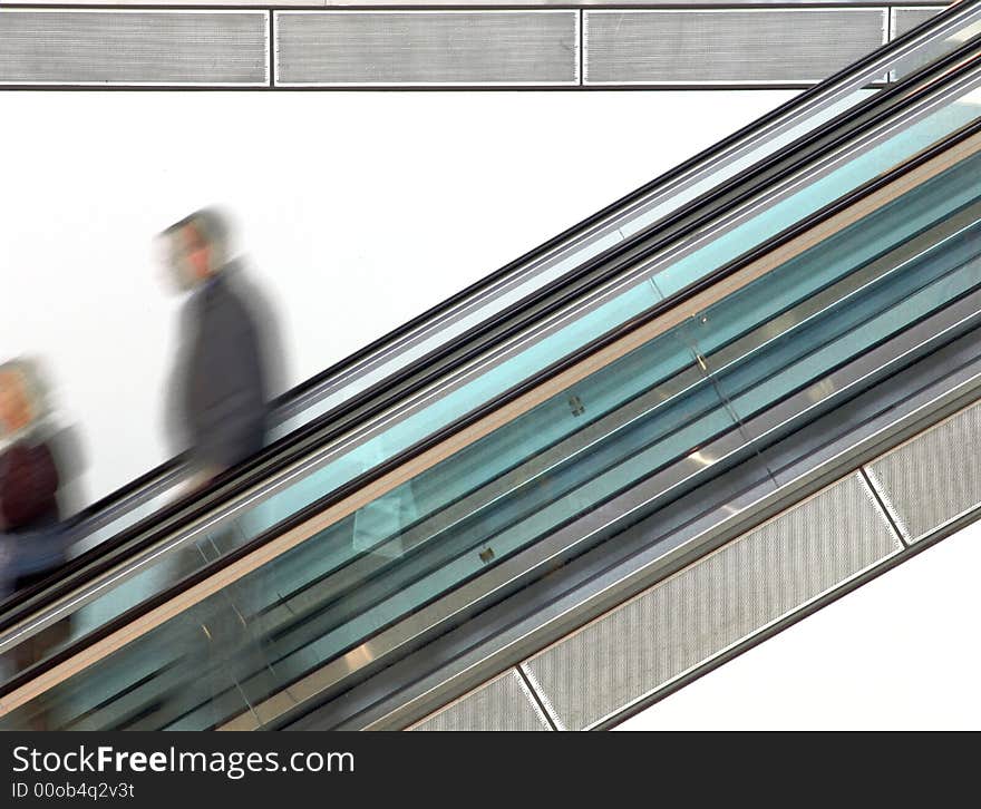 People walking on escalator (Blurred motion demonstrates the speed). People walking on escalator (Blurred motion demonstrates the speed)