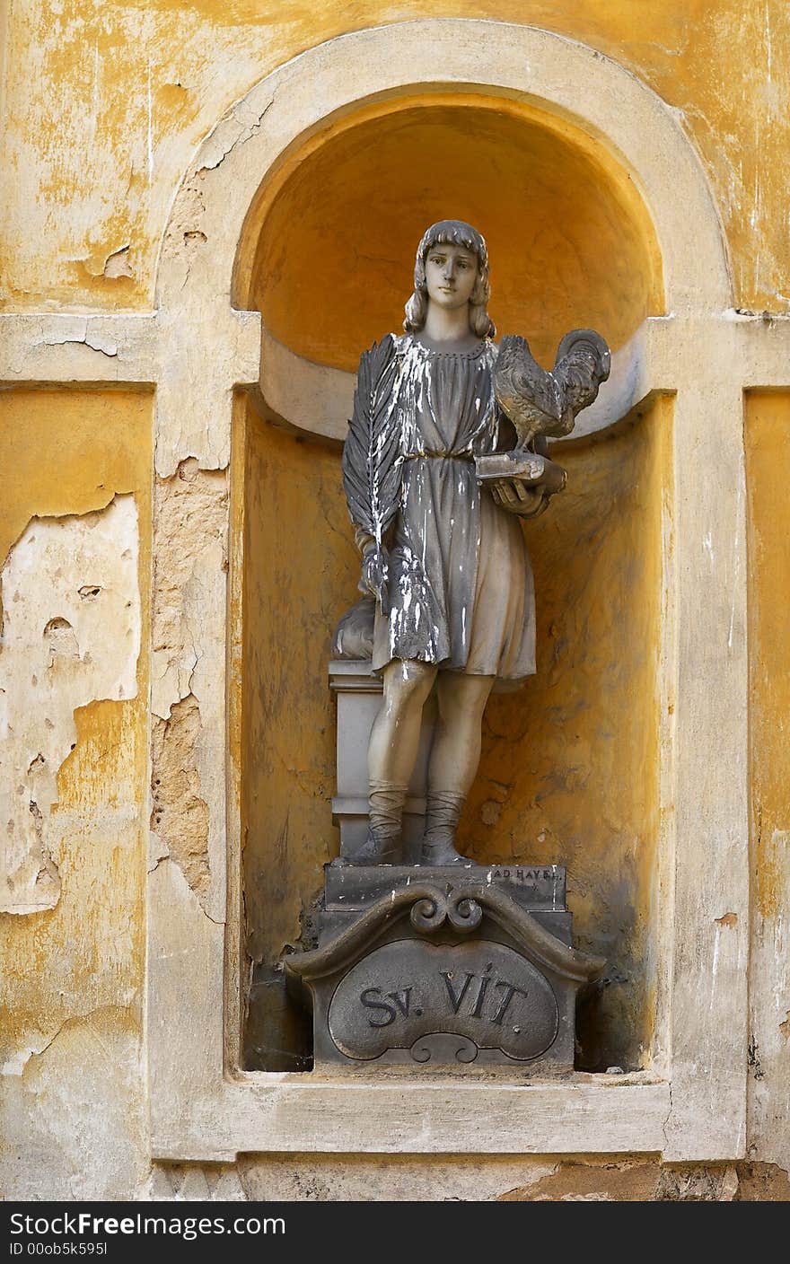 Statue of saint Vit with the book and the cock in a bay window of an old monastery