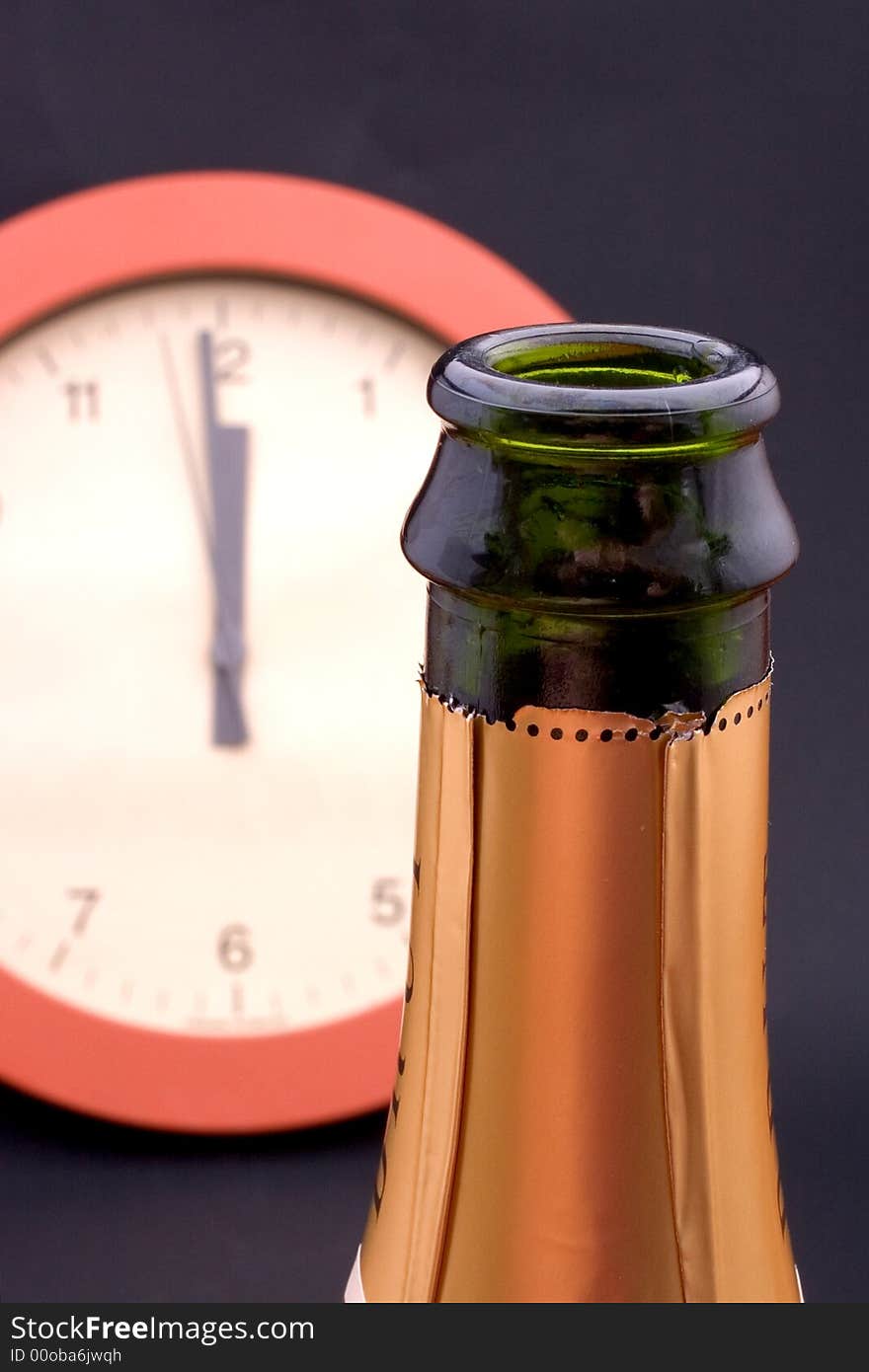 A clock ticking away the final seconds behind an uncorked bottle of champagne, shallow DOF, focus is on the bottle. A clock ticking away the final seconds behind an uncorked bottle of champagne, shallow DOF, focus is on the bottle