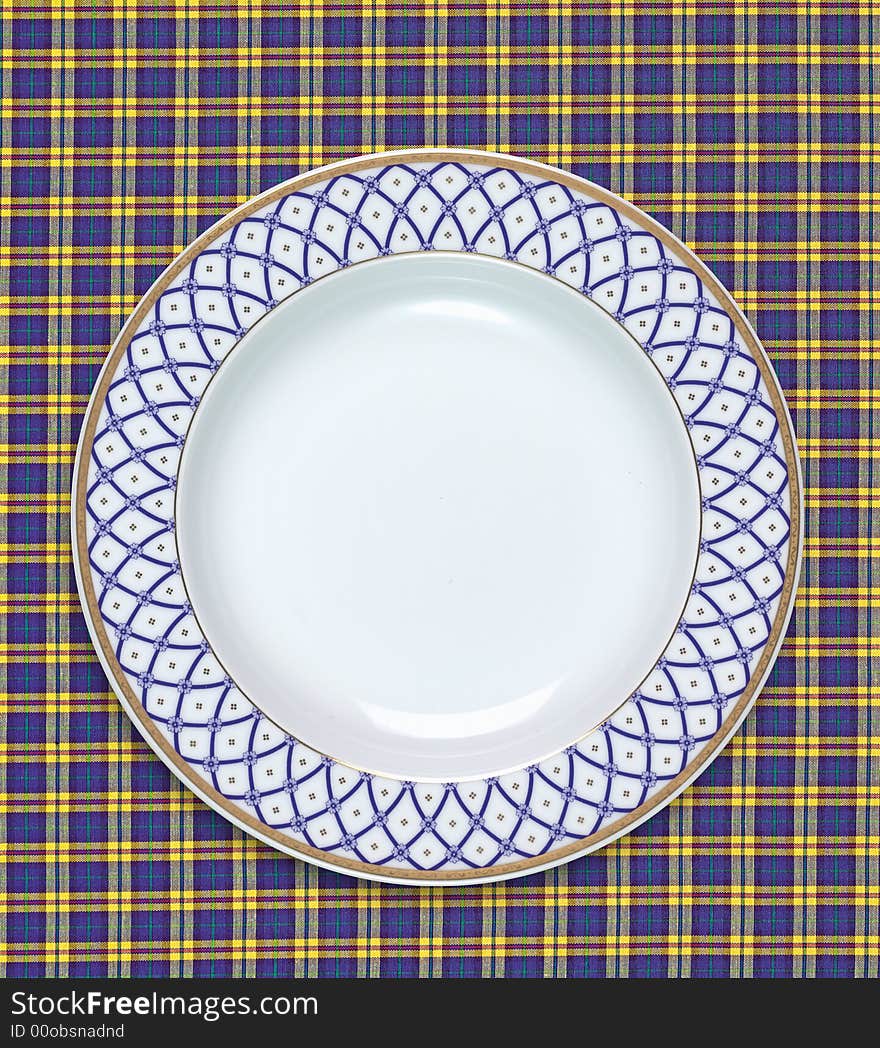 A empty dish on the table cloth