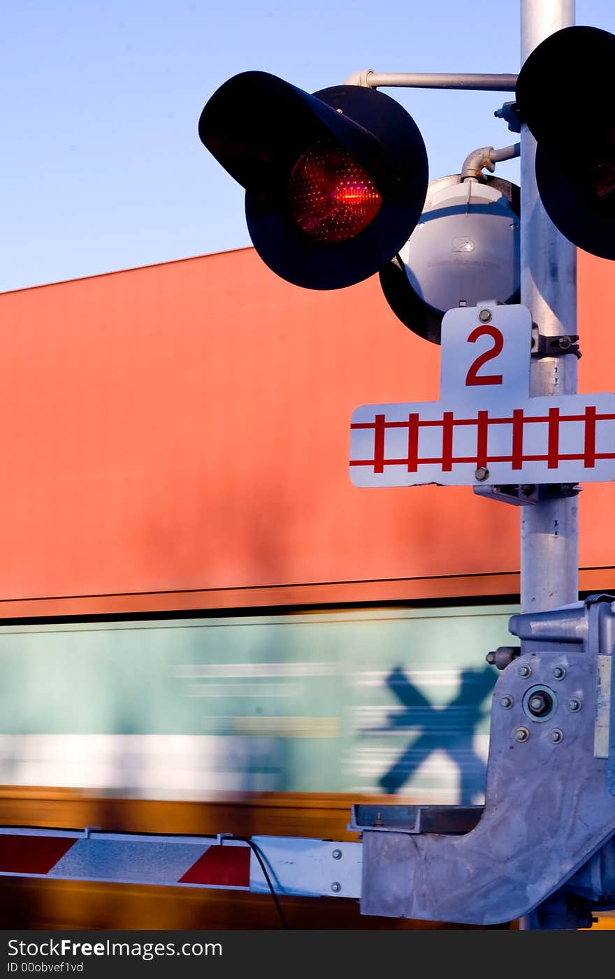 A train crossing with a fast train moving by in the background. A train crossing with a fast train moving by in the background.