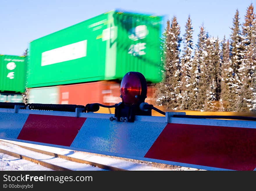 A train crossing with a fast train moving by in the background. A train crossing with a fast train moving by in the background.