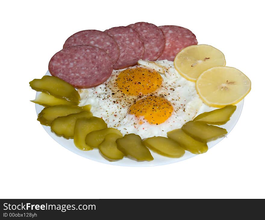 The isolated image of the fried eggs with salami, lemon and pickles with clipping path