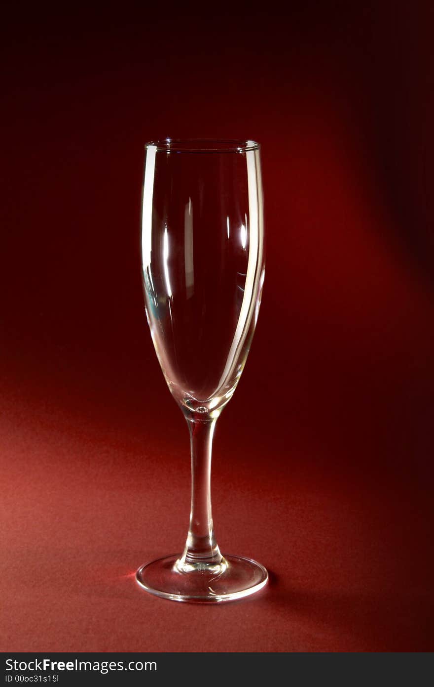 Single champagne glass on red background