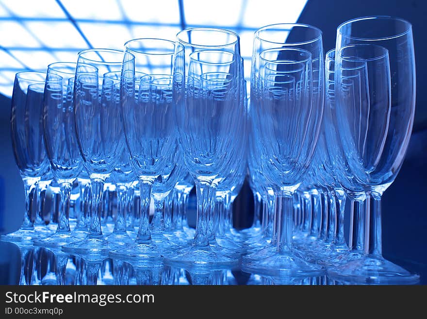 Bunch of empty champagne glasses at party, blue tones.