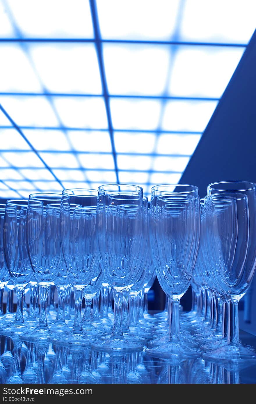 Bunch of empty champagne glasses at party, blue tones.