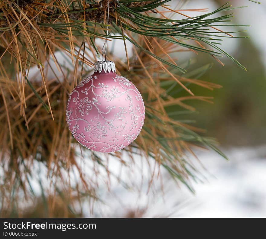 Pink and Silver Christmas Ornament in a snowy pine tree