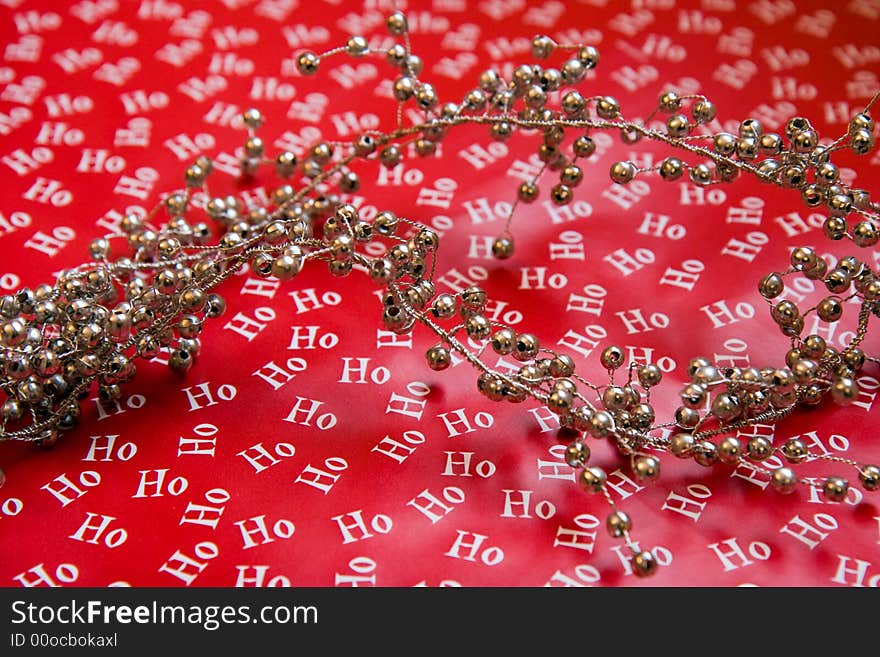 Red Christmas Wrapping paper with ho ho ho on it and silver garland beads