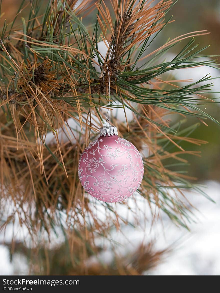 Pink and Silver Christmas Ornament in a snowy pine tree