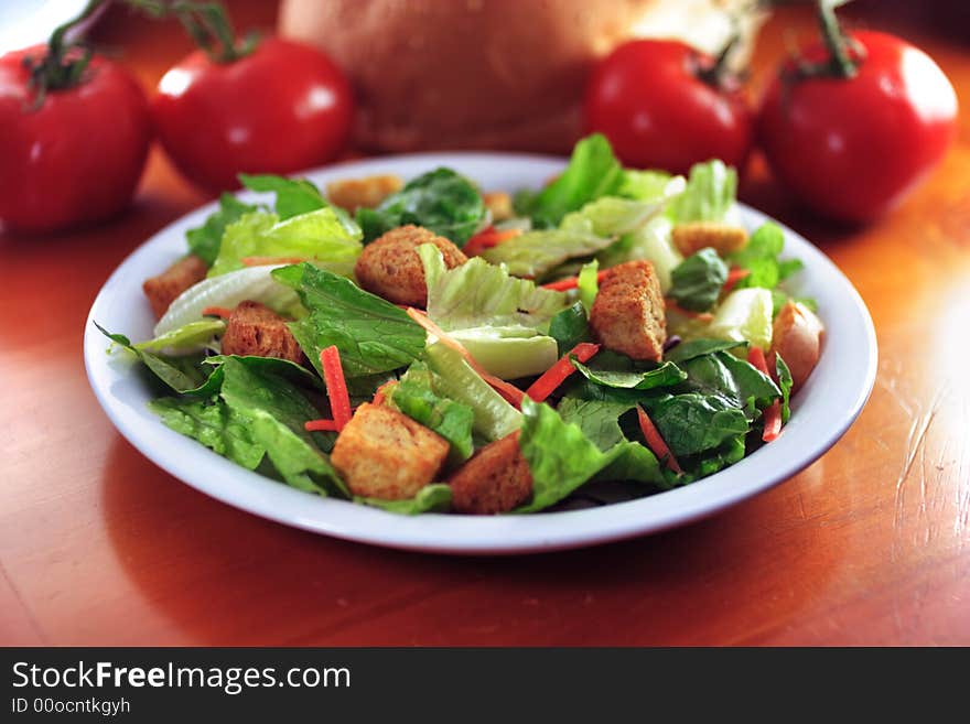 Restaurant salad on wooden table.