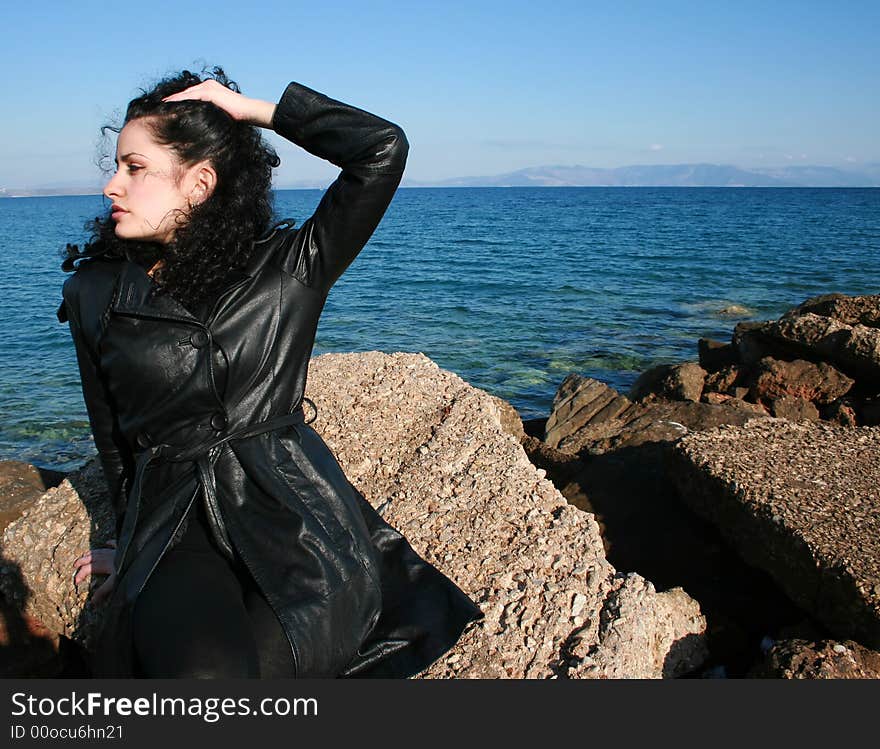 A brunette young beautiful woman with green eyes by the sea. A brunette young beautiful woman with green eyes by the sea