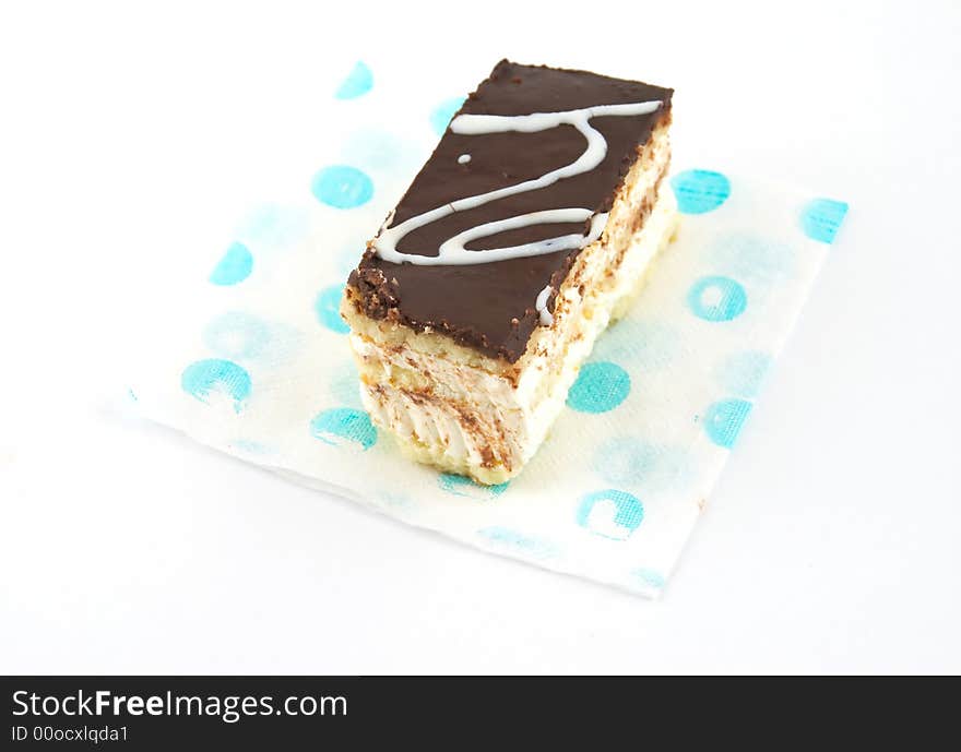 Cake under a layer of the chocolate, laying on a napkin