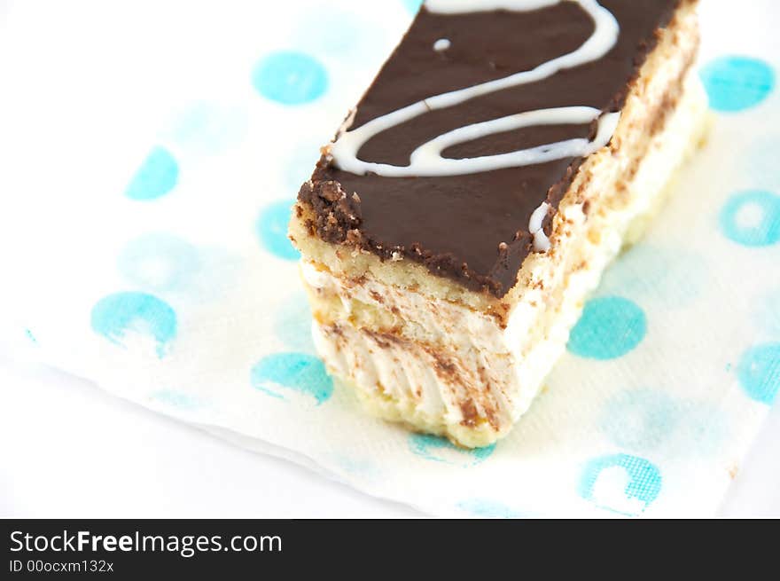 Cake under a layer of the chocolate, laying on a napkin