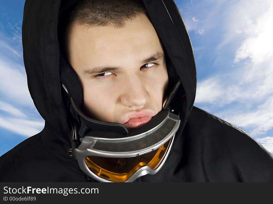 A teenager boy dressed in a snowboarding suit with googles acting fierce and determined. A teenager boy dressed in a snowboarding suit with googles acting fierce and determined.