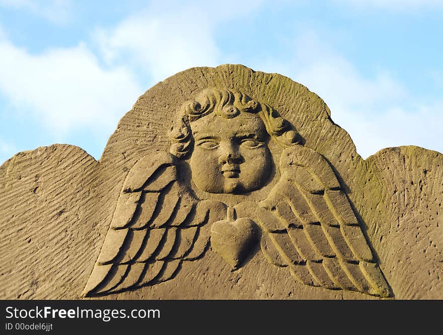 Old ancient Angels Face against blue sky