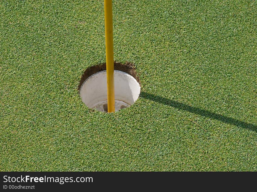 Empty putting hole with flag stick. Empty putting hole with flag stick