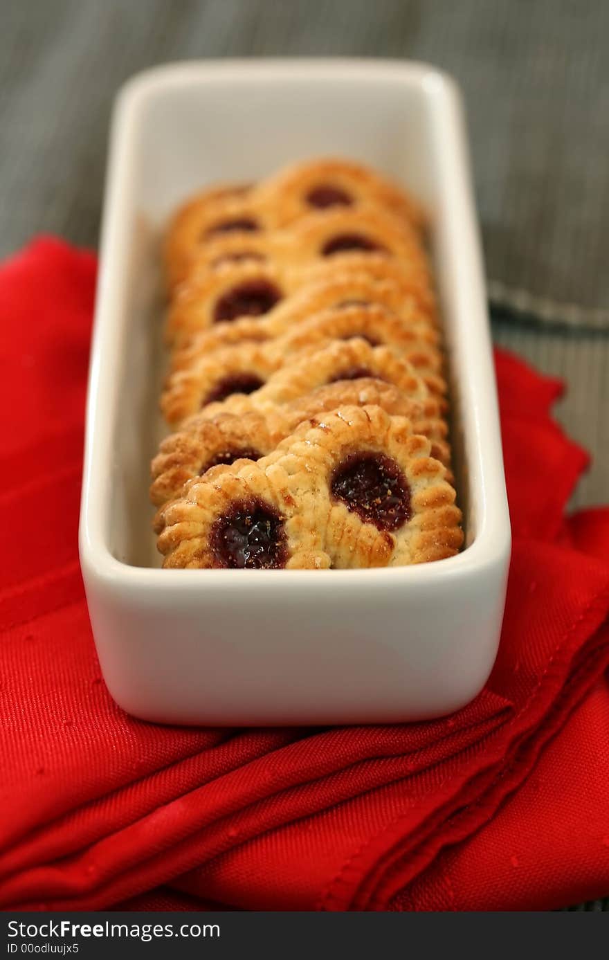 A plate of raspberry pretzel cookies with a red napkin