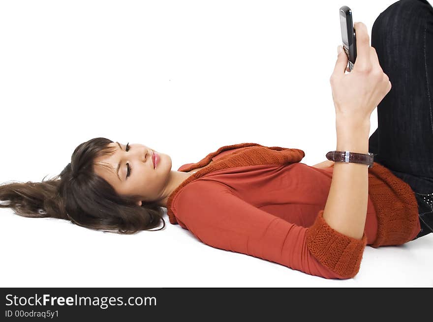 Young brunette girl with mobile phone on white background.