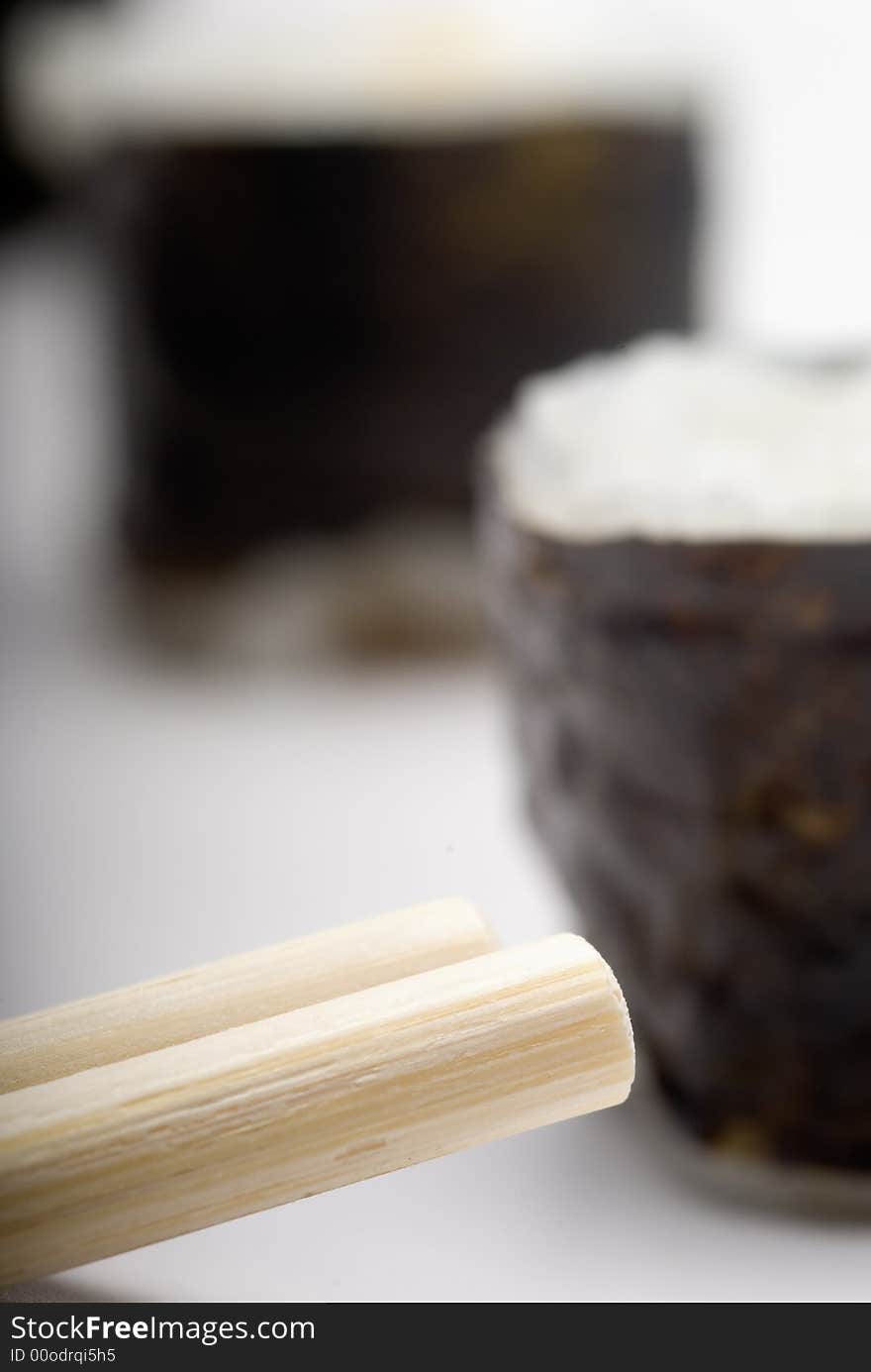 Composition of maki sushi, white late and a stick. Close focus and shallow depht of field used