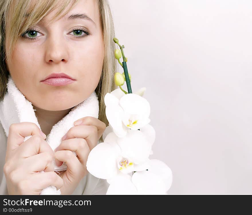 Close up of beautiful woman with wihite towel on the neck and white orchid. Close up of beautiful woman with wihite towel on the neck and white orchid