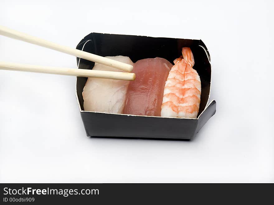 Three pieces of various nigiri in a black box with sticks. Three pieces of various nigiri in a black box with sticks.