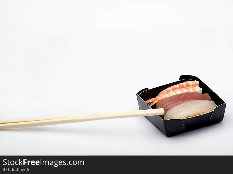 Three pieces of various nigiri in a black box with sticks. in a black box with sticks. Three pieces of various nigiri in a black box with sticks. in a black box with sticks.