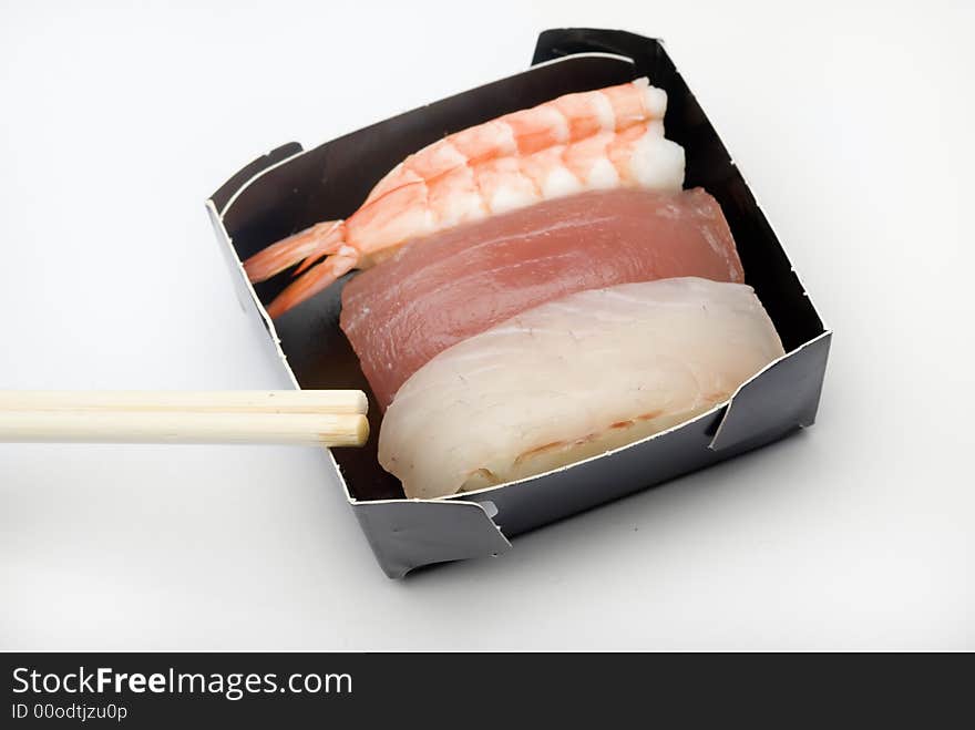 Three pieces of various nigiri in a black box with sticks.  in a black box with sticks. Three pieces of various nigiri in a black box with sticks.  in a black box with sticks.