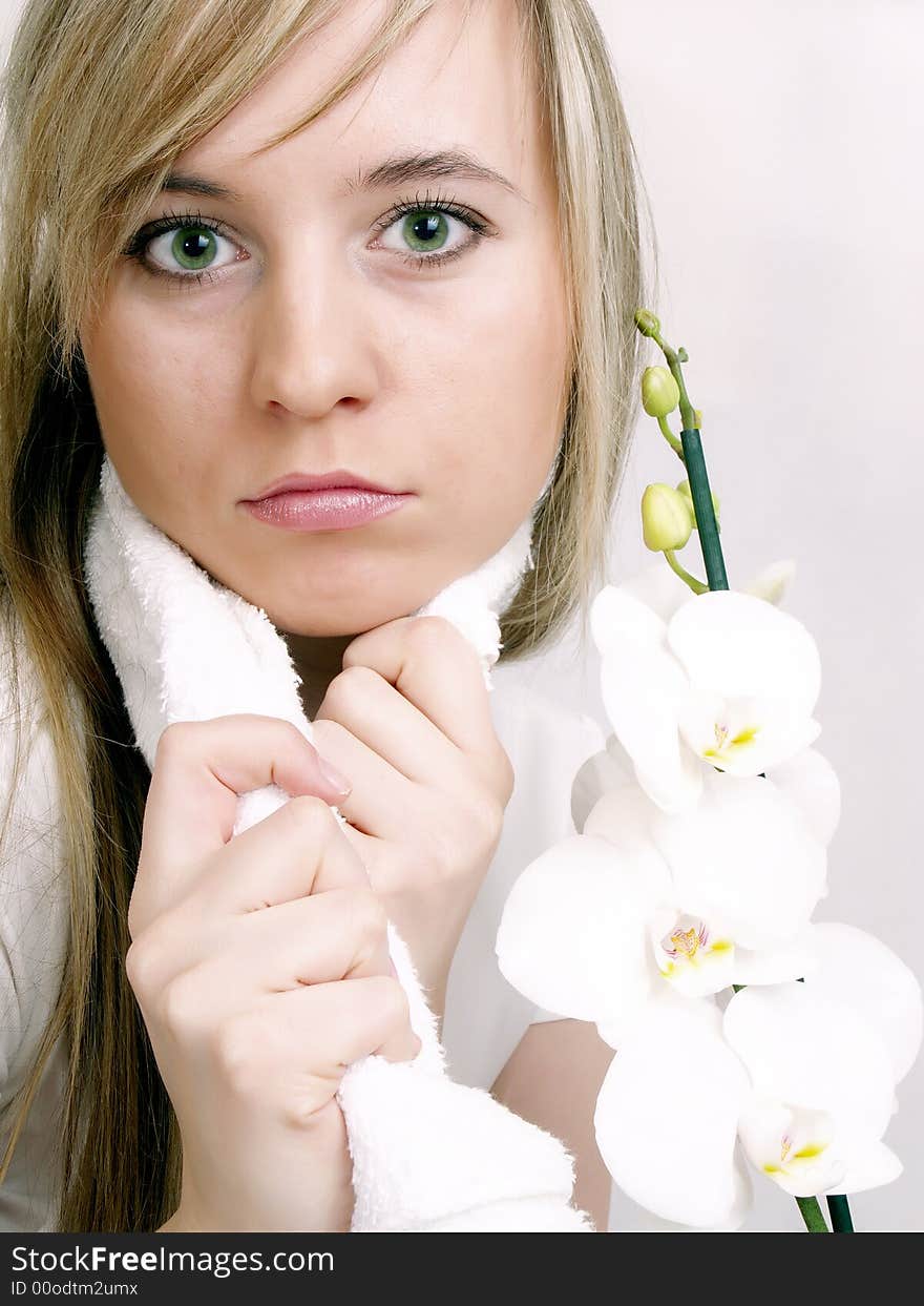 Close up of beautiful woman with white towel on the neck and white orchid. Close up of beautiful woman with white towel on the neck and white orchid