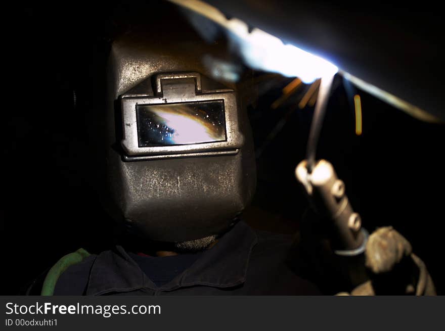 A welder at shipyard working at night. A welder at shipyard working at night