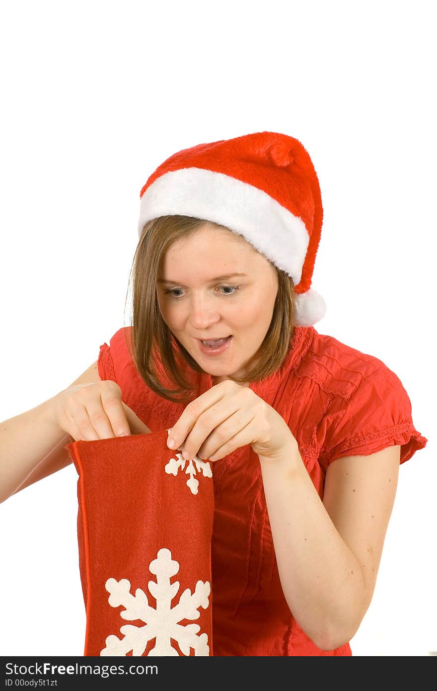 Young girl with cute smile and santa hat looking for her gift in red sock. Young girl with cute smile and santa hat looking for her gift in red sock